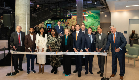 Group photo of speakers and leadership cutting the ribbon at the 4MLK grand opening